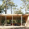 Le salon se déploie comme une vitrine panoramique sur le paysage.