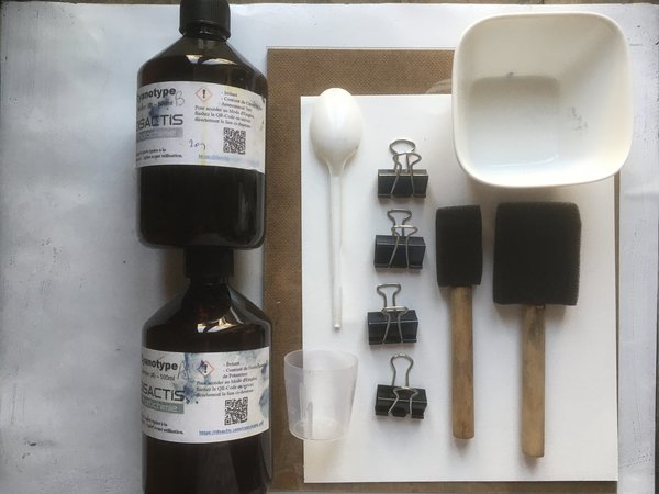 Le matériel : un support plastifié, ferricyanure de potassium et de citrate d’ammonium ferrique, un verre doseur, un récipient, une cuillère plastique, pinces à dessin, pinceaux mousse, un sous verre.