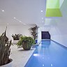 La piscine offre un bassin tout en longueur éclairé par la lumière naturelle et aboutit à un salon zen.