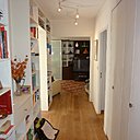 Avant les travaux : un couloir et une entrée encombrés par des rangements ouverts.