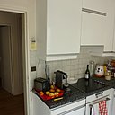 Avant les travaux : une cuisine aménagée avec des placards standard sans style.