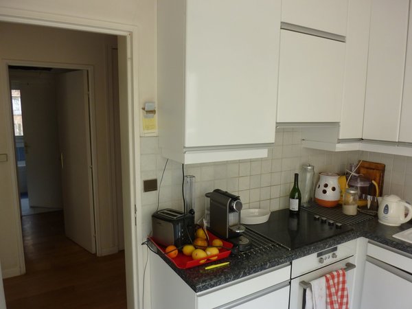 Avant les travaux : une cuisine aménagée avec des placards standard sans style.