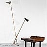A gauche, rare lampadaire mod. 1049, en marbre blanc et laiton, avec fût et diffuseurs orientables en métal laqué, création Vittoriano Vigano, 1952, édition Arteluce. Hauteur : 212 cm. A droite, table dite « Cubo Magico » de la série dite « Plurimi », en bois recouvert de laiton avec 4 tablettes et 2 portes, création Gabriella Crespi, 1970. Dimensions : 79 × 59 × 59 cm et 160 × 160 cm.