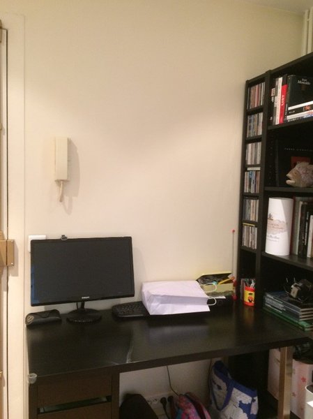 Avant : le coin bureau de l’entrée avec des rangements ouverts et du mobilier aux teintes foncées qui ne s’intègre pas dans l’espace.