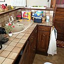 Avant travaux : des rangements de cuisine réduits en partie basse et des matériaux démodés.