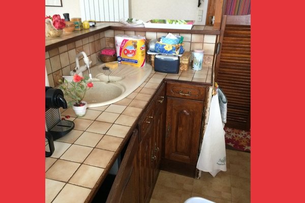 Avant travaux : des rangements de cuisine réduits en partie basse et des matériaux démodés.