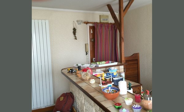 Avant travaux : une entrée directe dans la pièce de vie avec une cuisine simplement cachée par une porte.