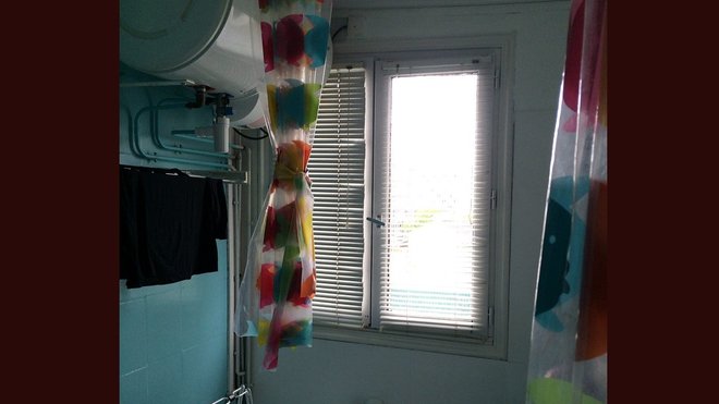 Avant travaux : une salle de bains avec un ballon d’eau chaude et une tuyauterie apparente inesthétiques.