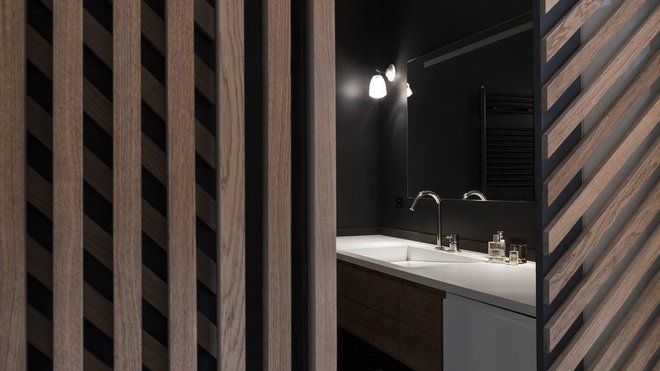 La salle de bains rénovée joue la carte minimaliste du noir et blanc.