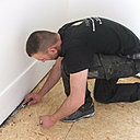 Etape 17 : Bien nettoyer en dessous des plinthes pour faciliter la pose des lames de parquet en bordure des plinthes.