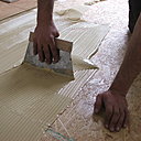 Etape 19 : La colle est étalée avec la spatule colle parquet. Il est primordial de bien progresser par zones de demi-mètre carré et cela dans le but d’avoir un temps ouvert d’encollage suffisant, au risque de voir le dépôt de colle sécher et durcir.