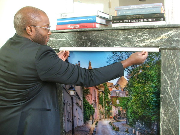 Etape 4 : fixer la moulure en bois sur le haut du visuel, en veillant à bien appuyer dessus. Ainsi le visuel sera bien aligné au niveau du linteau de la cheminée.