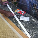 Etape 3 : afin de bien caler le visuel décoratif dans l’enfoncement du foyer de la cheminée, il est recommandé de placer une moulure en bois. Pour faciliter la tâche, le plus simple est d’utiliser de Patafix. Ensuite, placer sur le revers de la moulure de fines pastilles de Patafix, espacées de 10 cm.