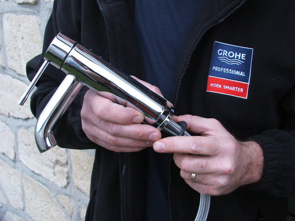 Etape 4 :  préparation du nouveau robinet. Fixer les flexibles sous le robinet, ainsi que les deux tiges filetées à mi-hauteur. Poser le joint à la base du robinet.