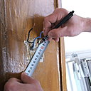 Etape 4 : marquer sur le mur les deux trous de perçage. Utiliser un mètre ruban pour plus de précision dans l’intervalle des deux emplacements de perçage, en vous reportant au dos du socle en marbre de la sonnette pour que la cotation soit exacte.