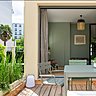 La terrasse est meublée avec du mobilier peint dans une nuance de vert tendre qui s’associe à la couleur de la végétation.