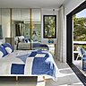 La chambre communique directement avec la terrasse, grâce à des baies vitrées à ouverture totale.