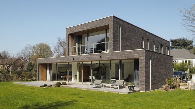 Les couleurs nuancées du parement en brique s’accordent avec celles des arbres et du bois des auvents.