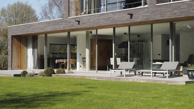 Les châssis discrets et graphiques des baies vitrées, dessinant des cadres sur le paysage, abolissent les frontières entre l’intérieur et l’extérieur.