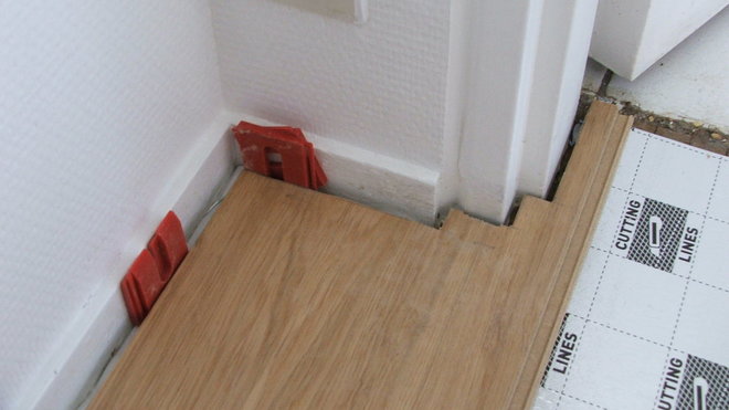 Etape 5 : En bout de mur, il faudra découper la lame selon les obstacles apparents. Ici, la lame sera découpée de manière à suivre parfaitement l’huisserie de porte, tout en laissant un jeu périphérique comme pour le mur.