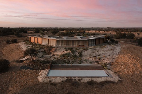 Au sommet d’une colline, une maison de plain-pied qui épouse la topographie du lieu.