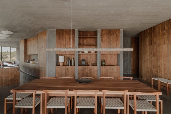 Les couleurs des assises composées d’un tressage de sangles font écho aux teintes du béton. Les bois chaleureux du mobilier s’accordent avec les lambris des murs.