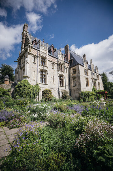 Le Château de Clères avec ses arbres majestueux et ses terrasses plantées de fleurs.